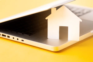 close-up-house-figure-with-laptop